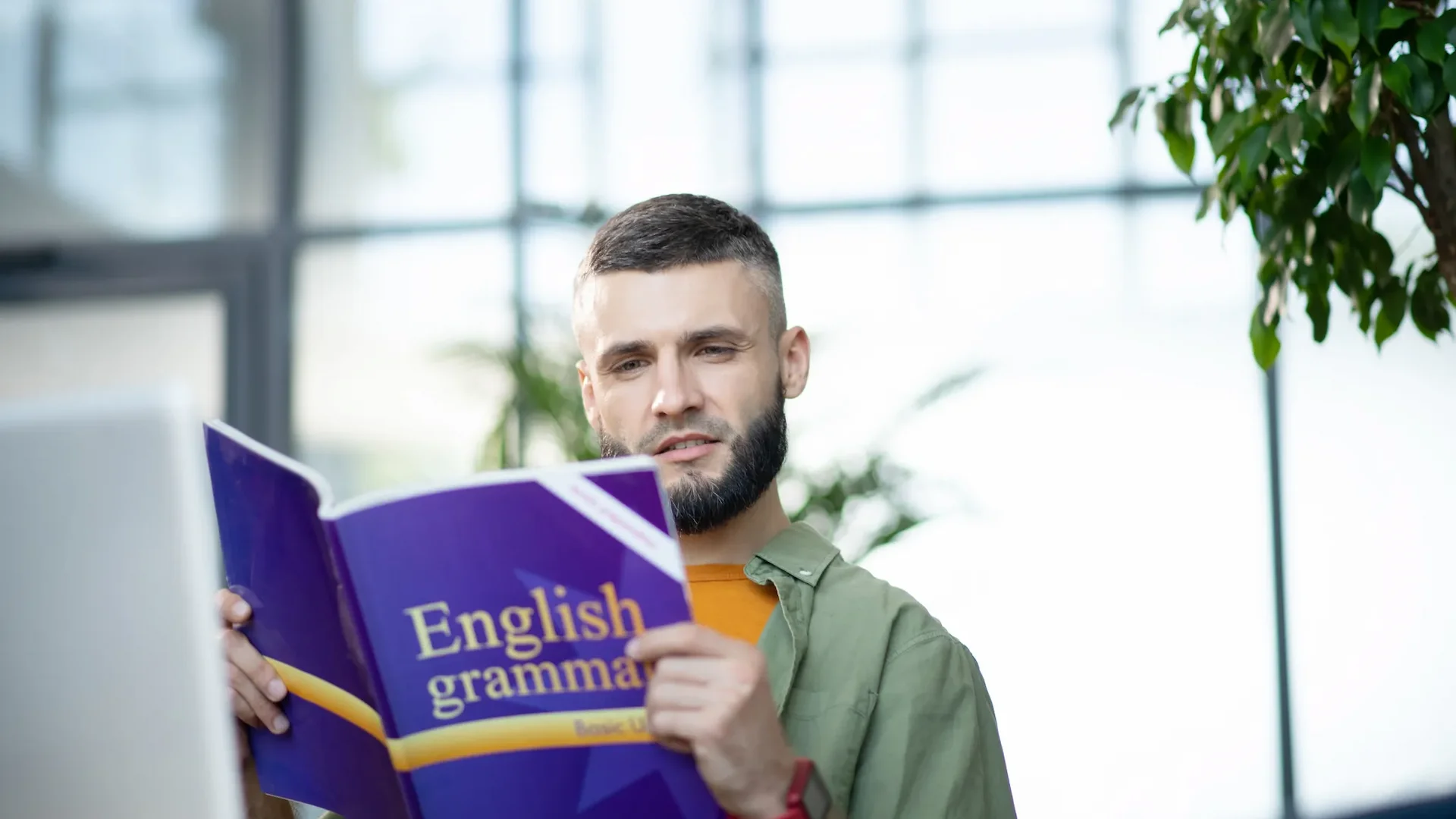 Bearded young man studying english grammar